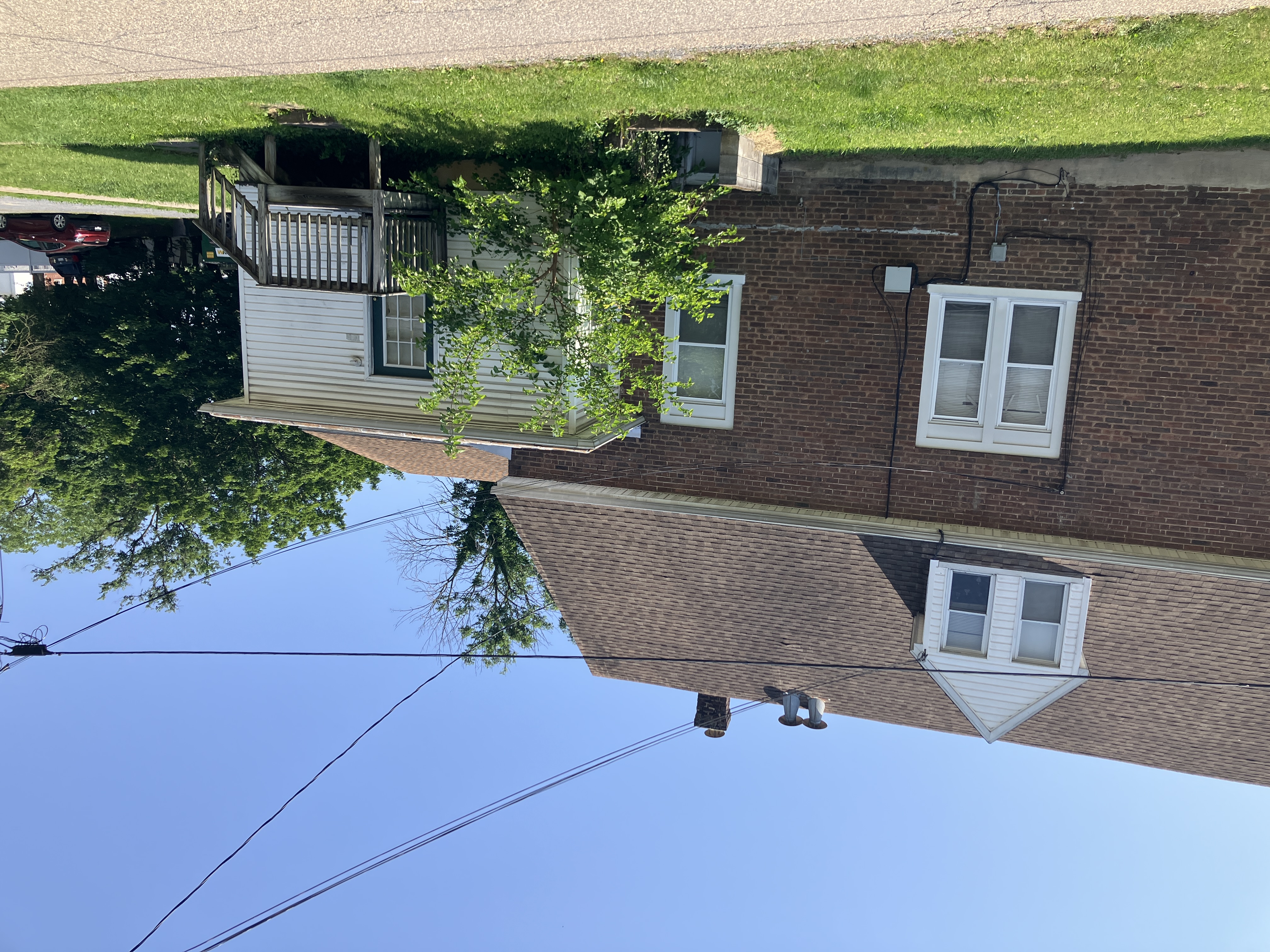 Brick apartment building with a side entrance and lawn