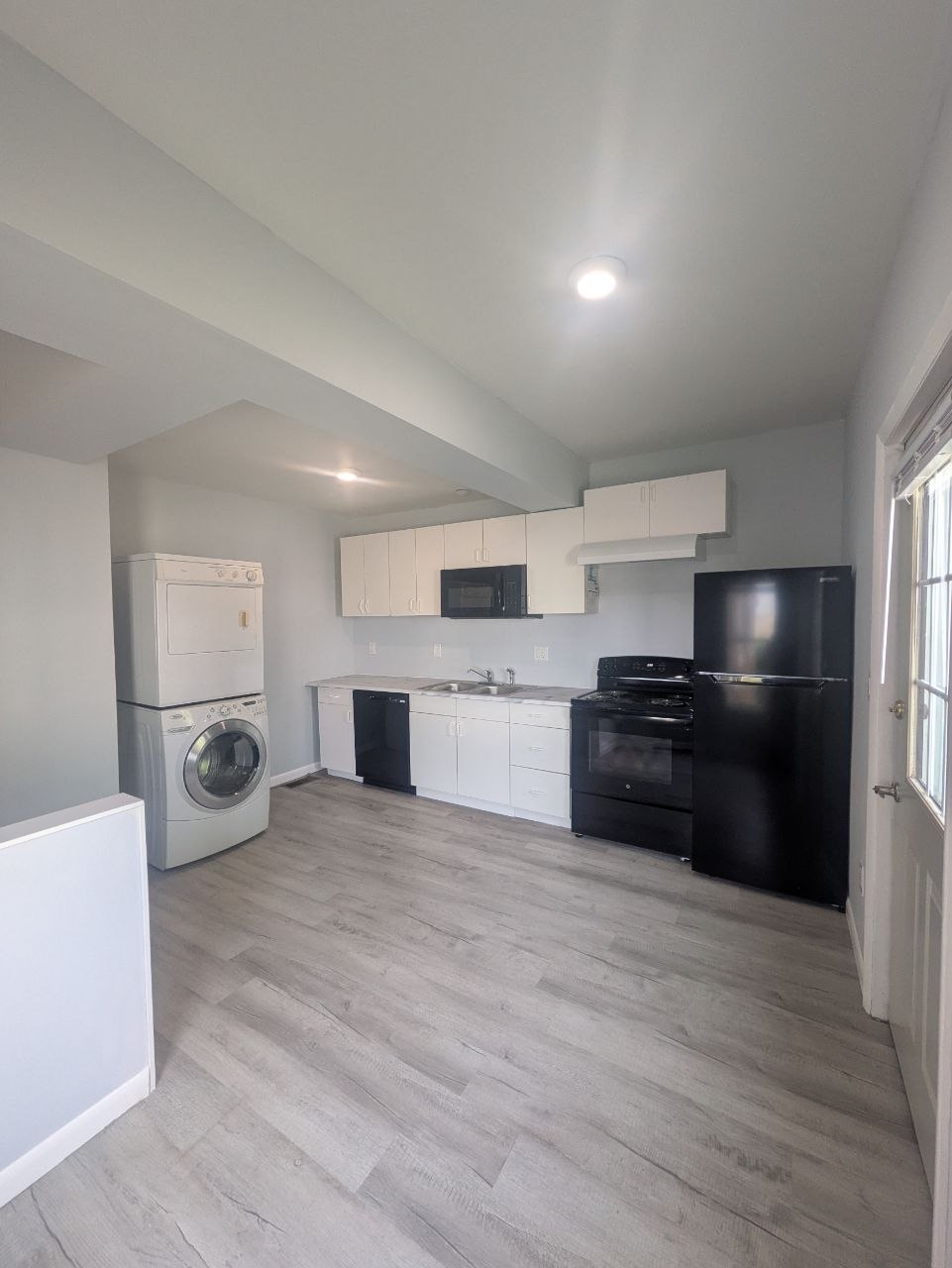Kitchen with white cabinetry and full appliances
